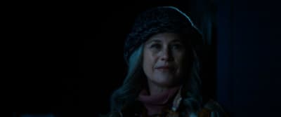 a woman wearing a hat in the dark