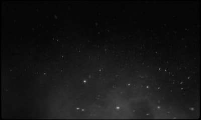 a black and white photo of snow falling