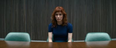 a woman sitting at a table in front of a wall