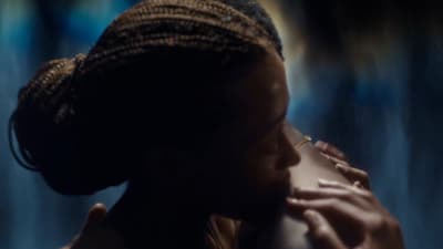 a woman with braids on her head holding a man