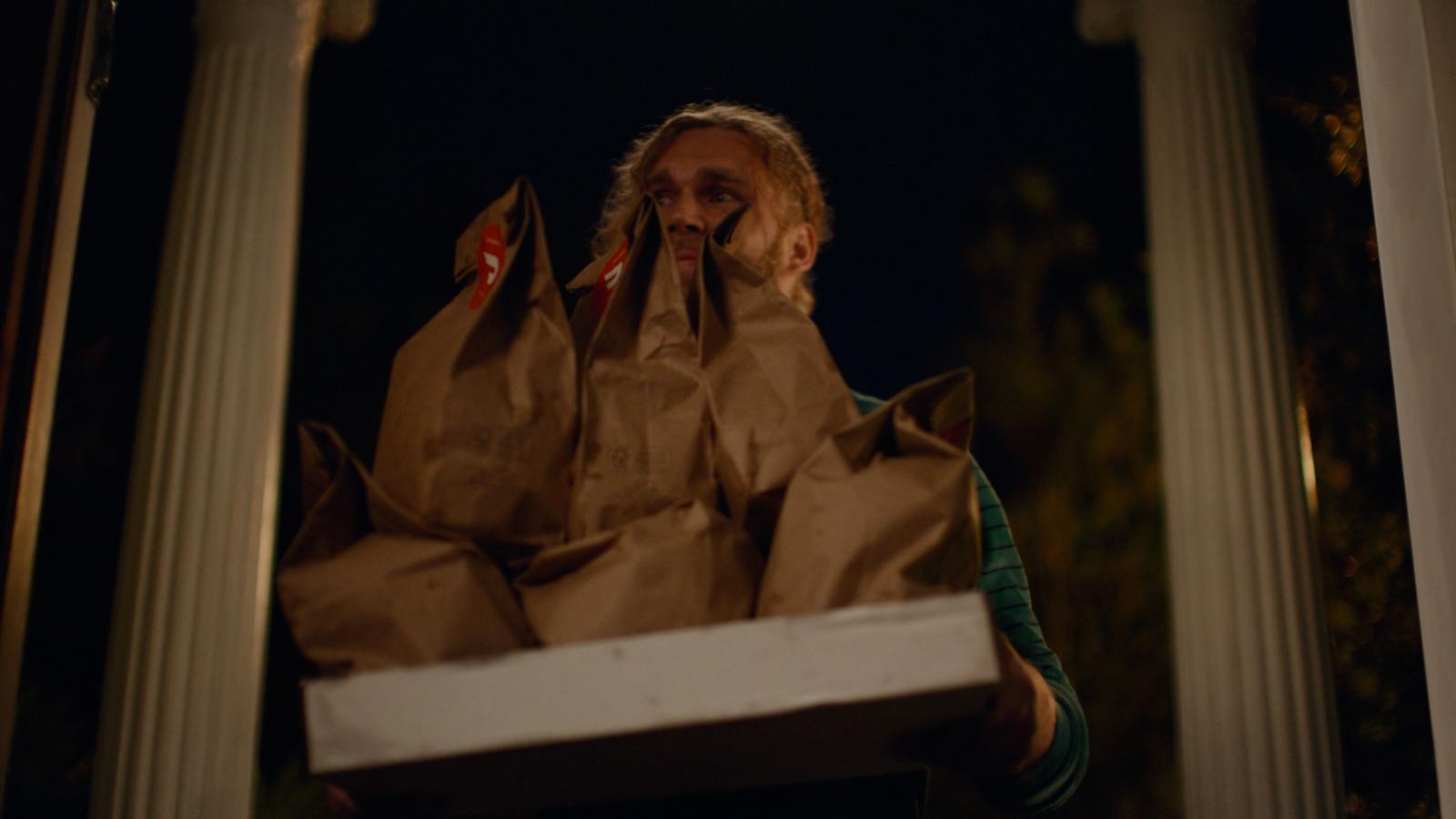 a woman holding a box with bags on it