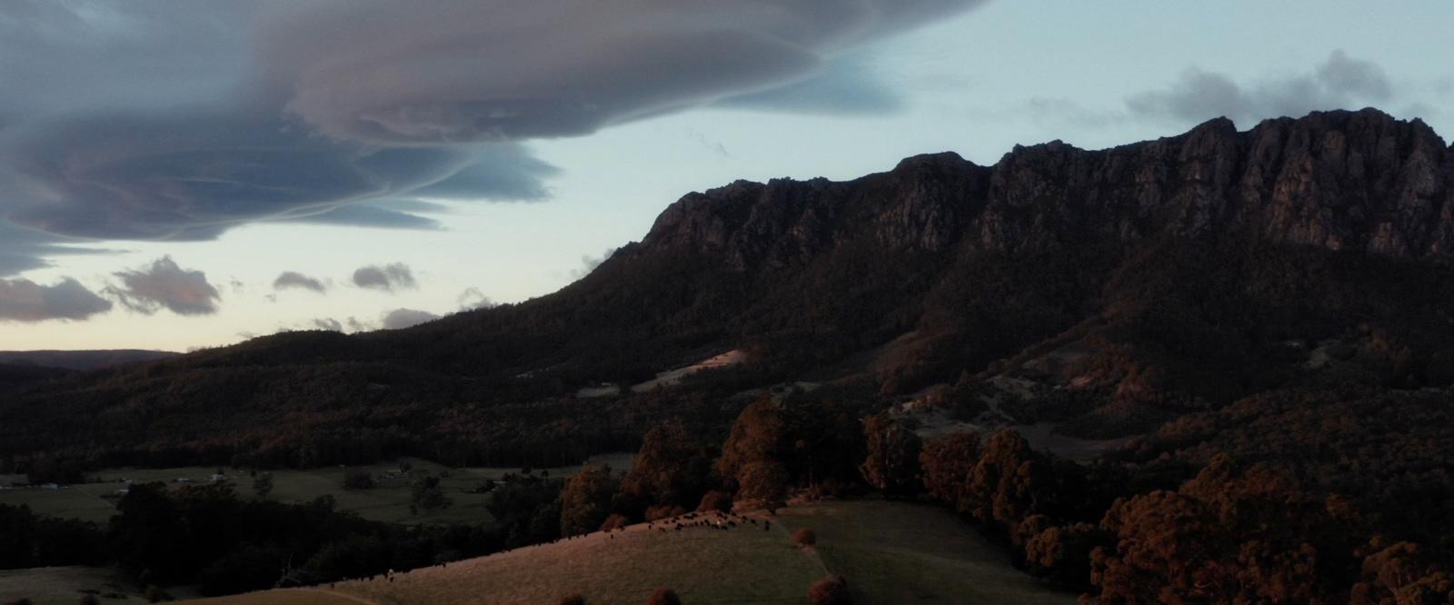 a view of a mountain with clouds in the sky