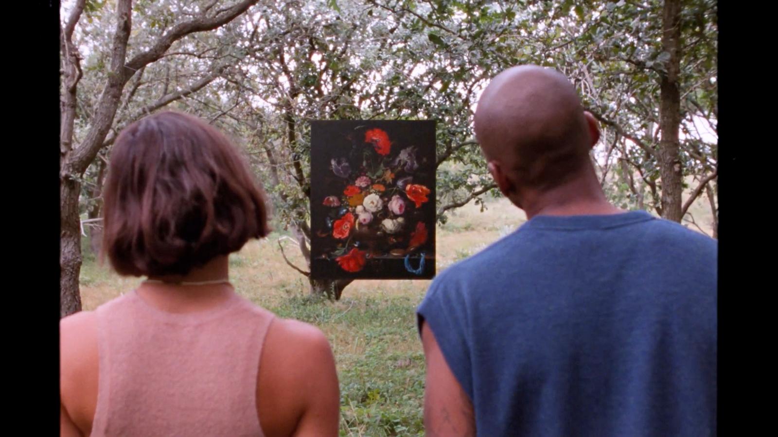 a man and a woman looking at a painting