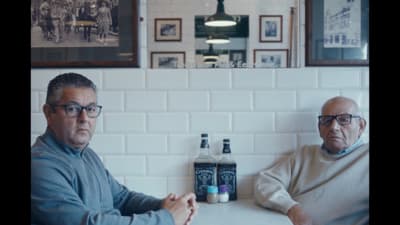 two men sitting at a table in a restaurant