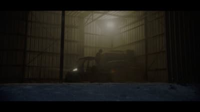 a person standing in a dark room next to a tractor