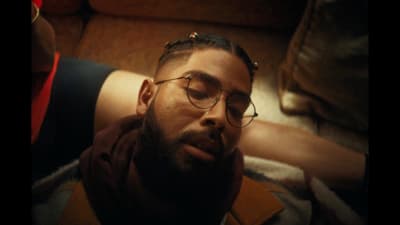 a man with glasses laying on a couch