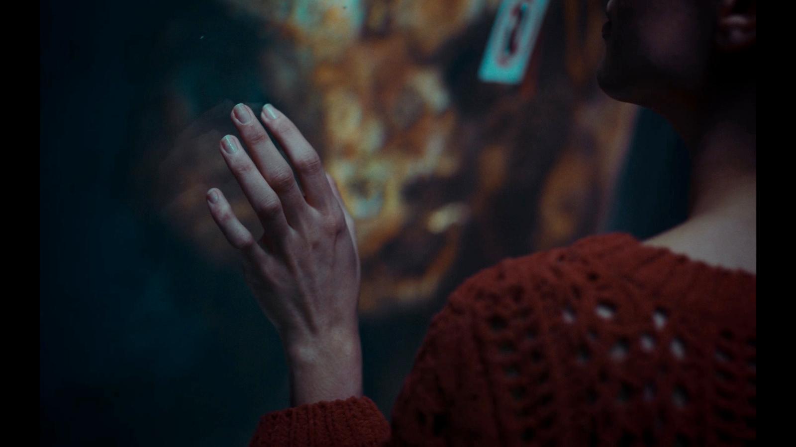 a woman in a red sweater holding her hands together