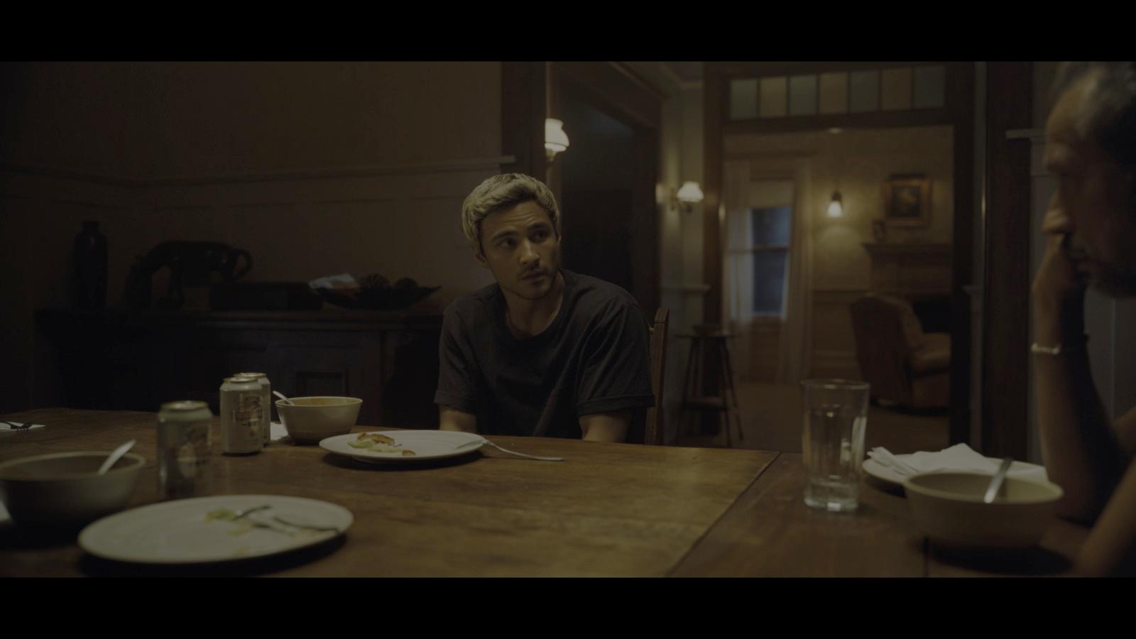 a man sitting at a table with a plate of food in front of him