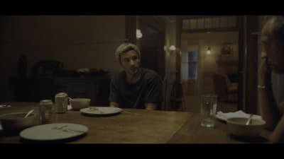 a man sitting at a table with a plate of food in front of him