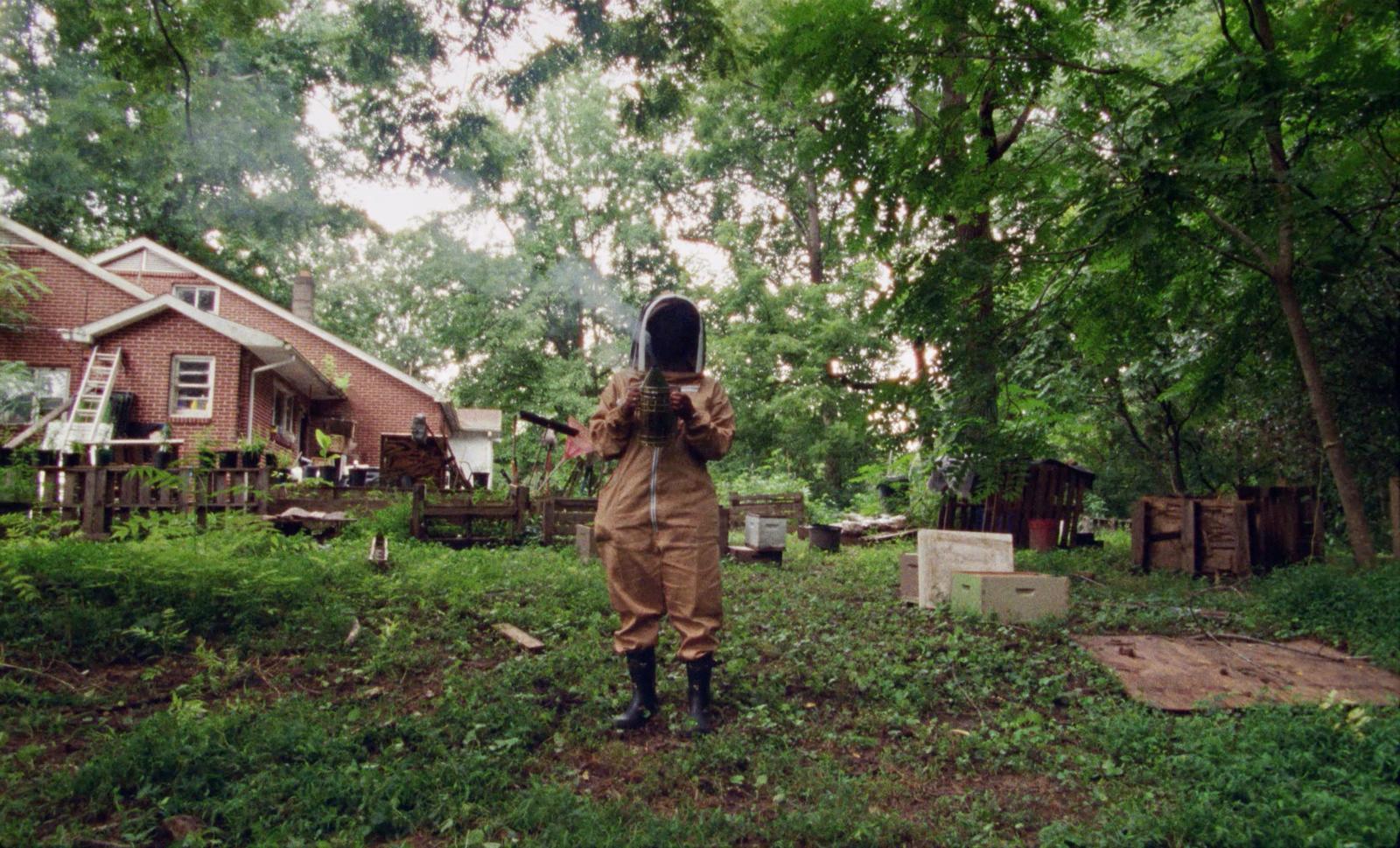 a person in a brown coverall holding a camera