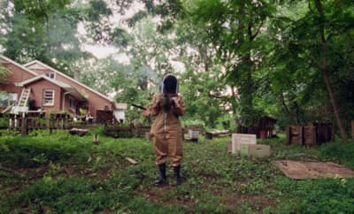 a person in a brown coverall holding a camera