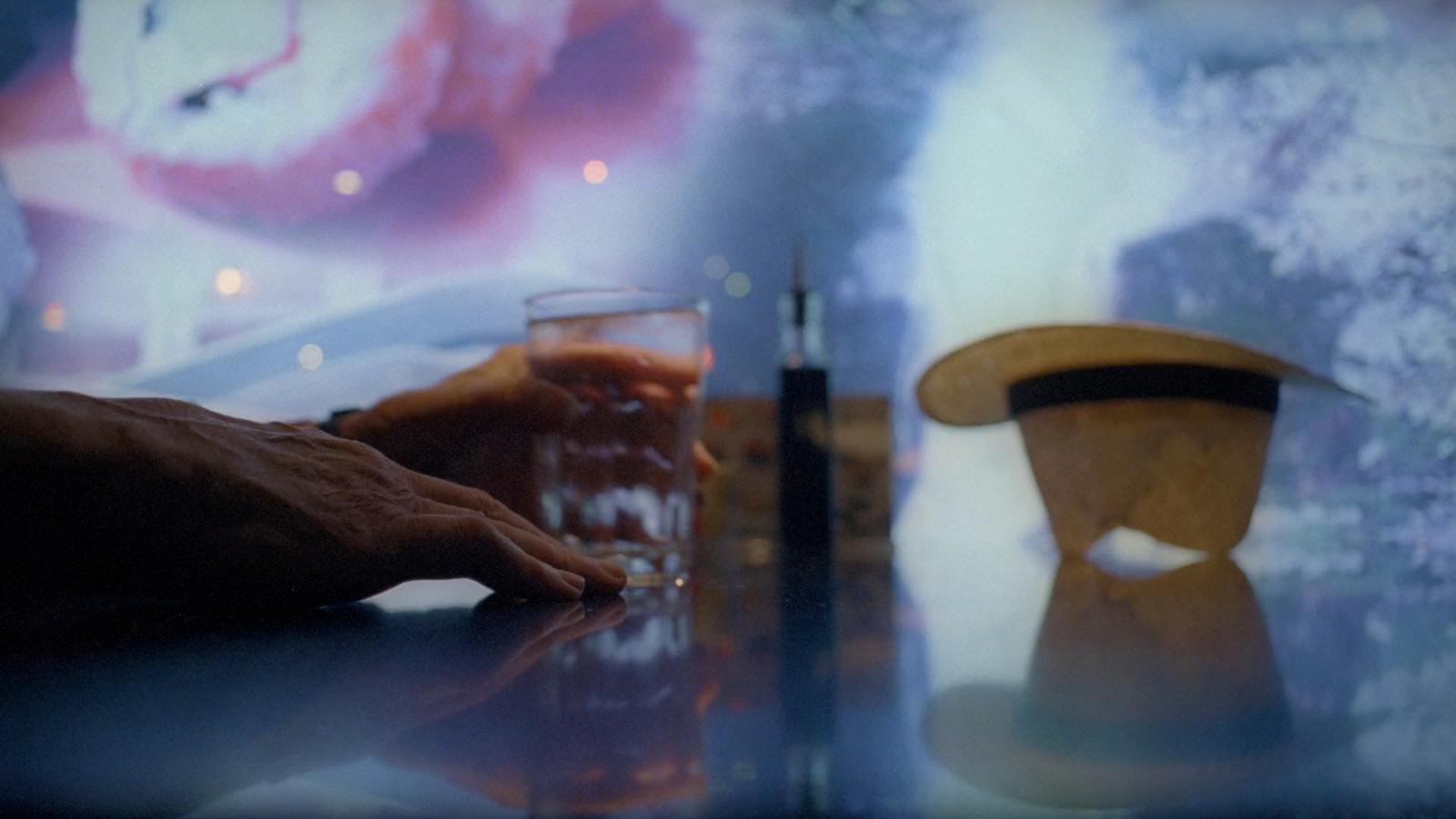 a person sitting at a table with a glass of beer