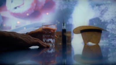 a person sitting at a table with a glass of beer