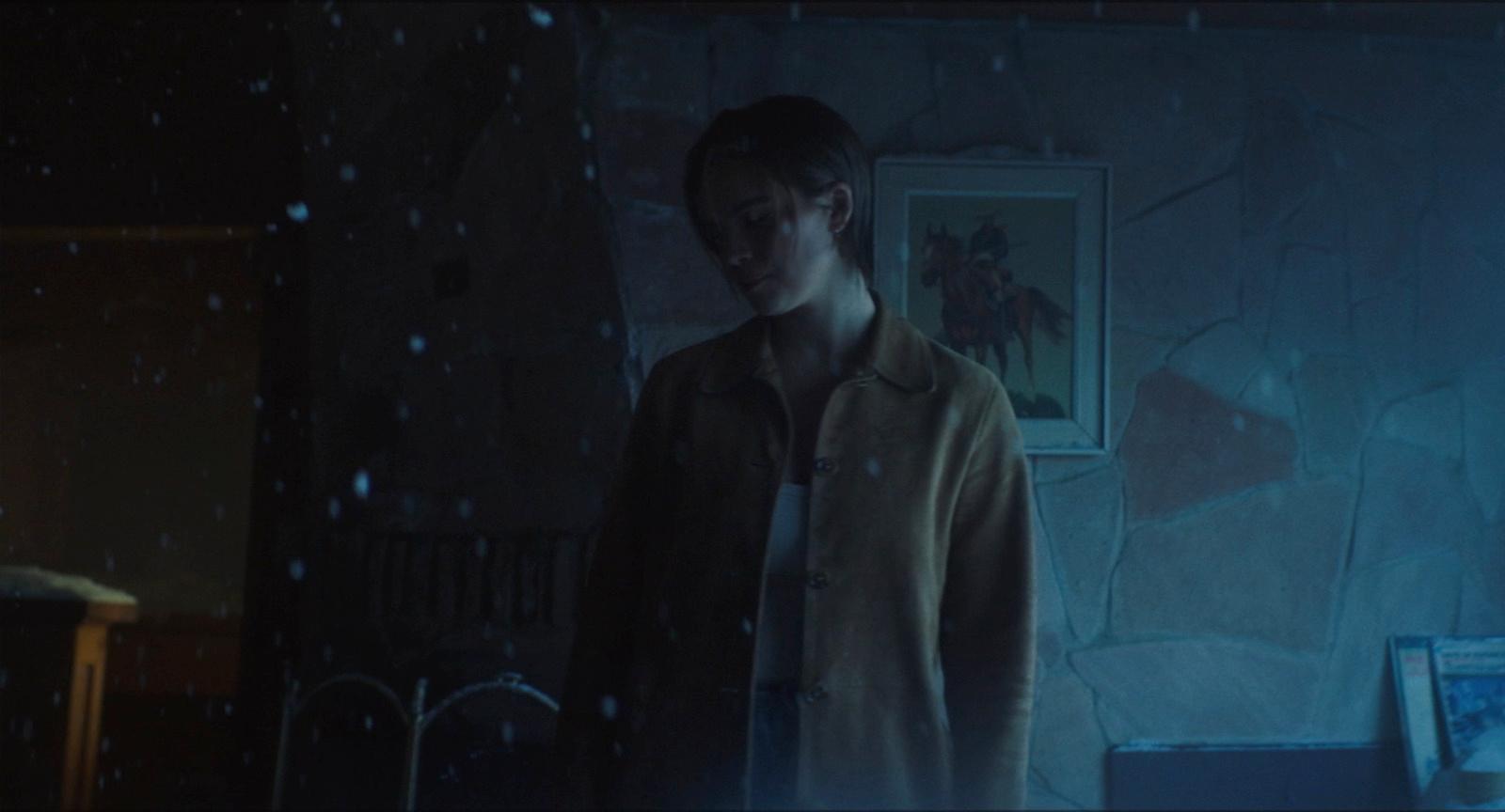 a man standing in a room with a painting on the wall