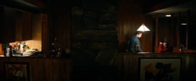 a man standing in a dark room next to a counter