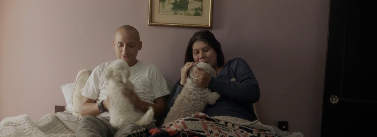 a man and a woman sitting on a bed