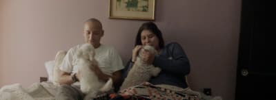 a man and a woman sitting on a bed