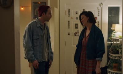 a woman standing next to a man in a hallway