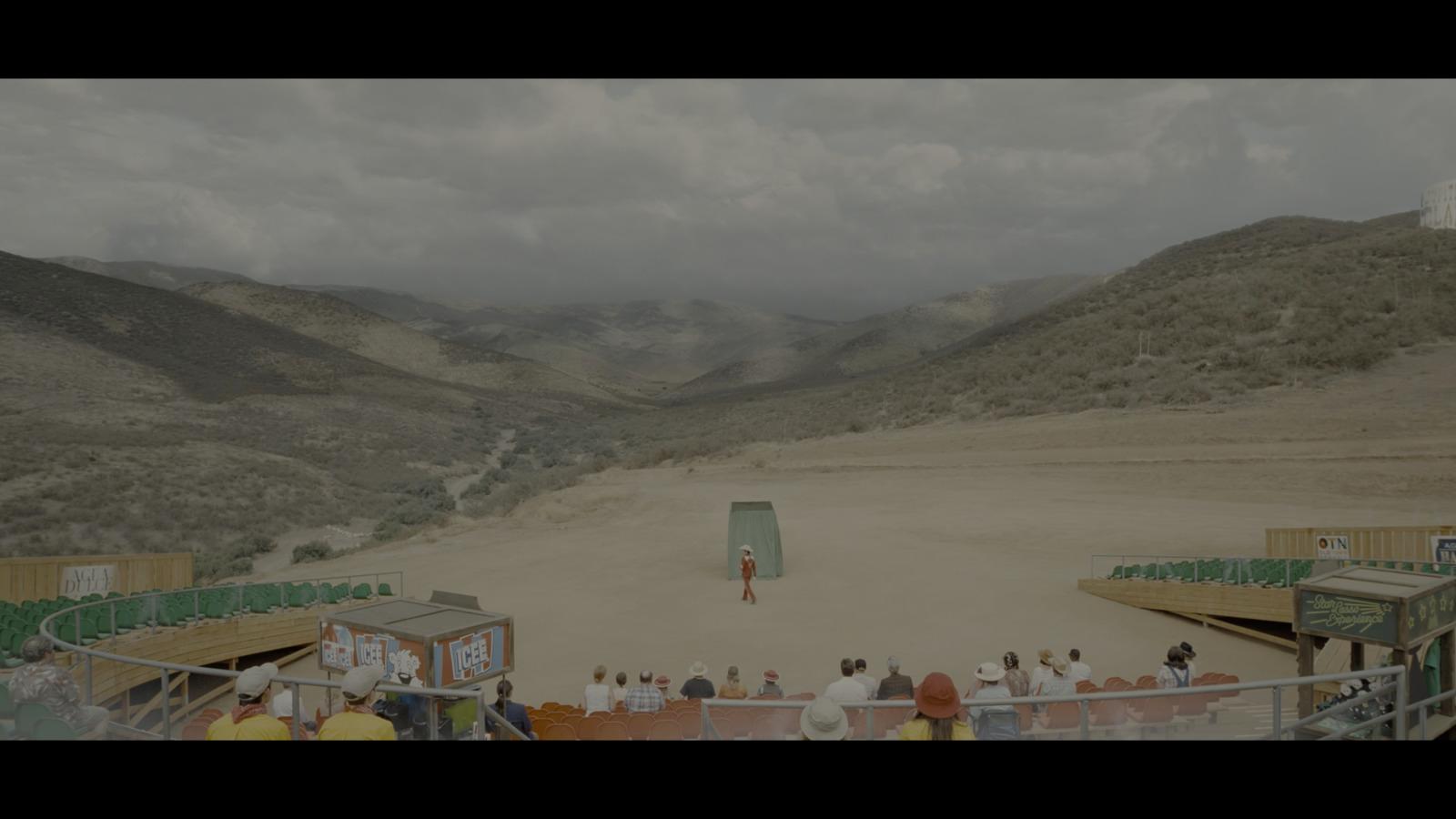 a group of people standing around a dirt field