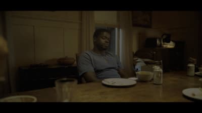 a man sitting at a table with a plate of food