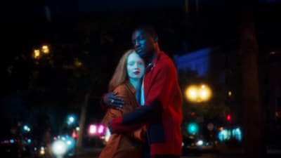 a man and a woman standing in the street at night