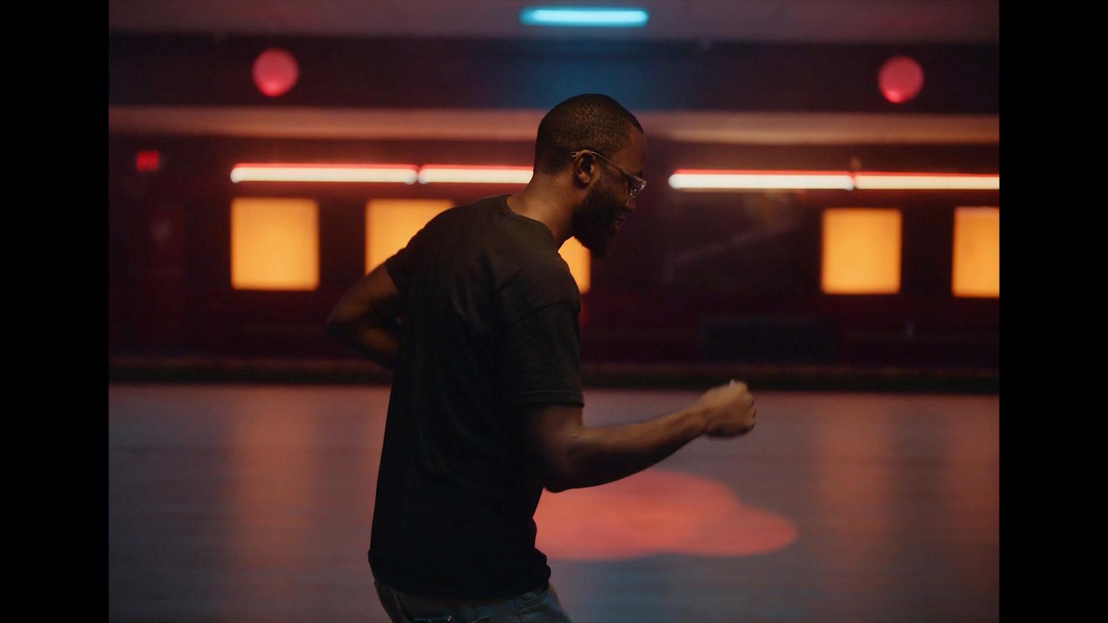 a man standing in a room holding a remote