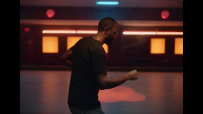 a man standing in a room holding a remote