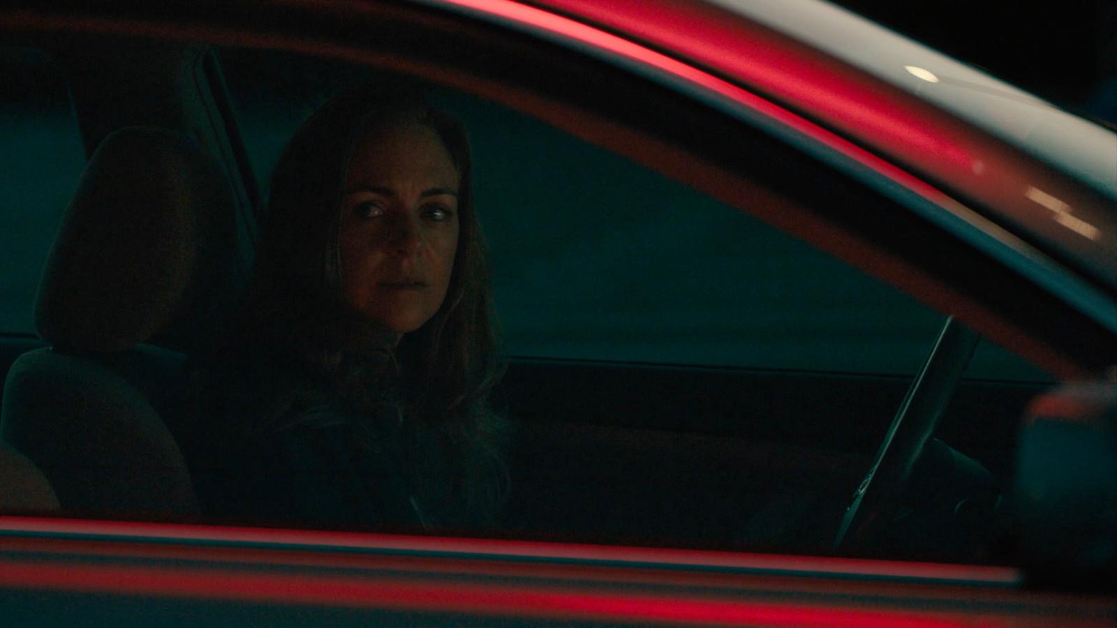 a woman sitting in a car at night