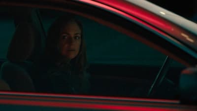 a woman sitting in a car at night