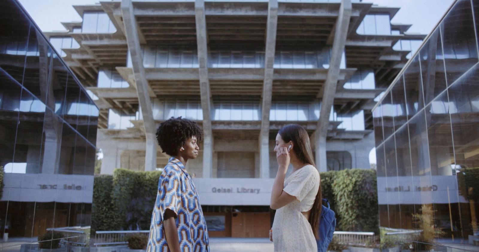 a couple of women standing next to each other in front of a building