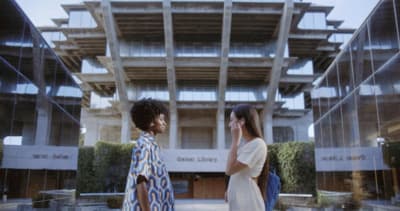 a couple of women standing next to each other in front of a building