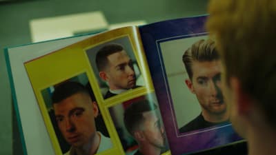 a man is looking at a book with pictures of him