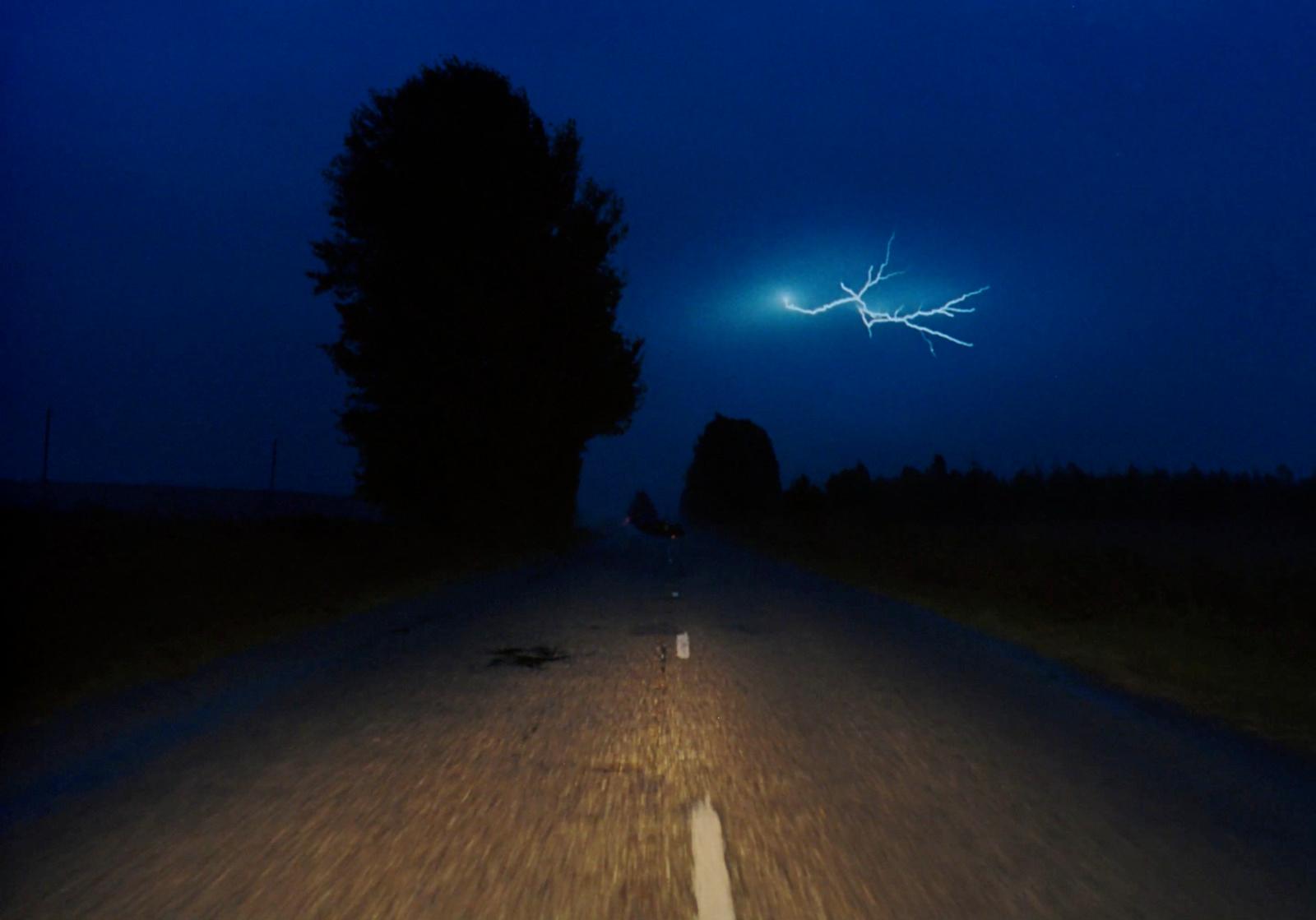 a car driving down a road at night