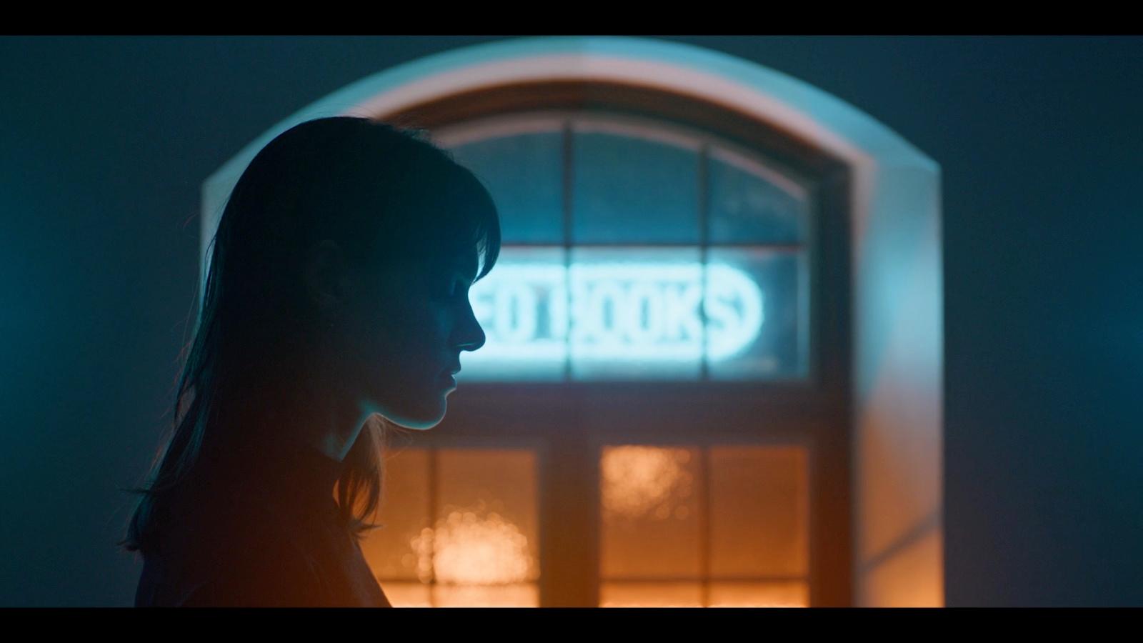 a woman standing in front of a building at night