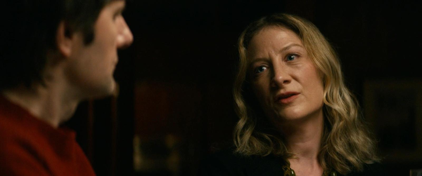 a woman standing next to a man in a dark room