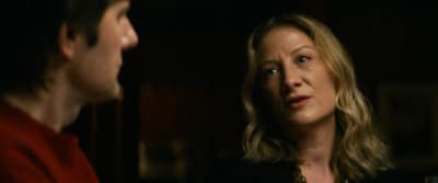 a woman standing next to a man in a dark room