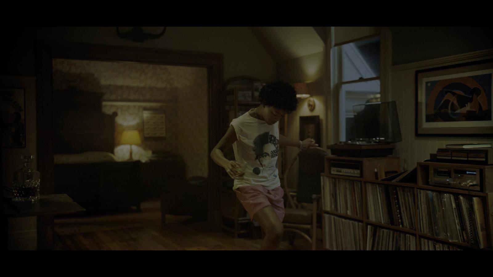 a man standing in a living room next to a window