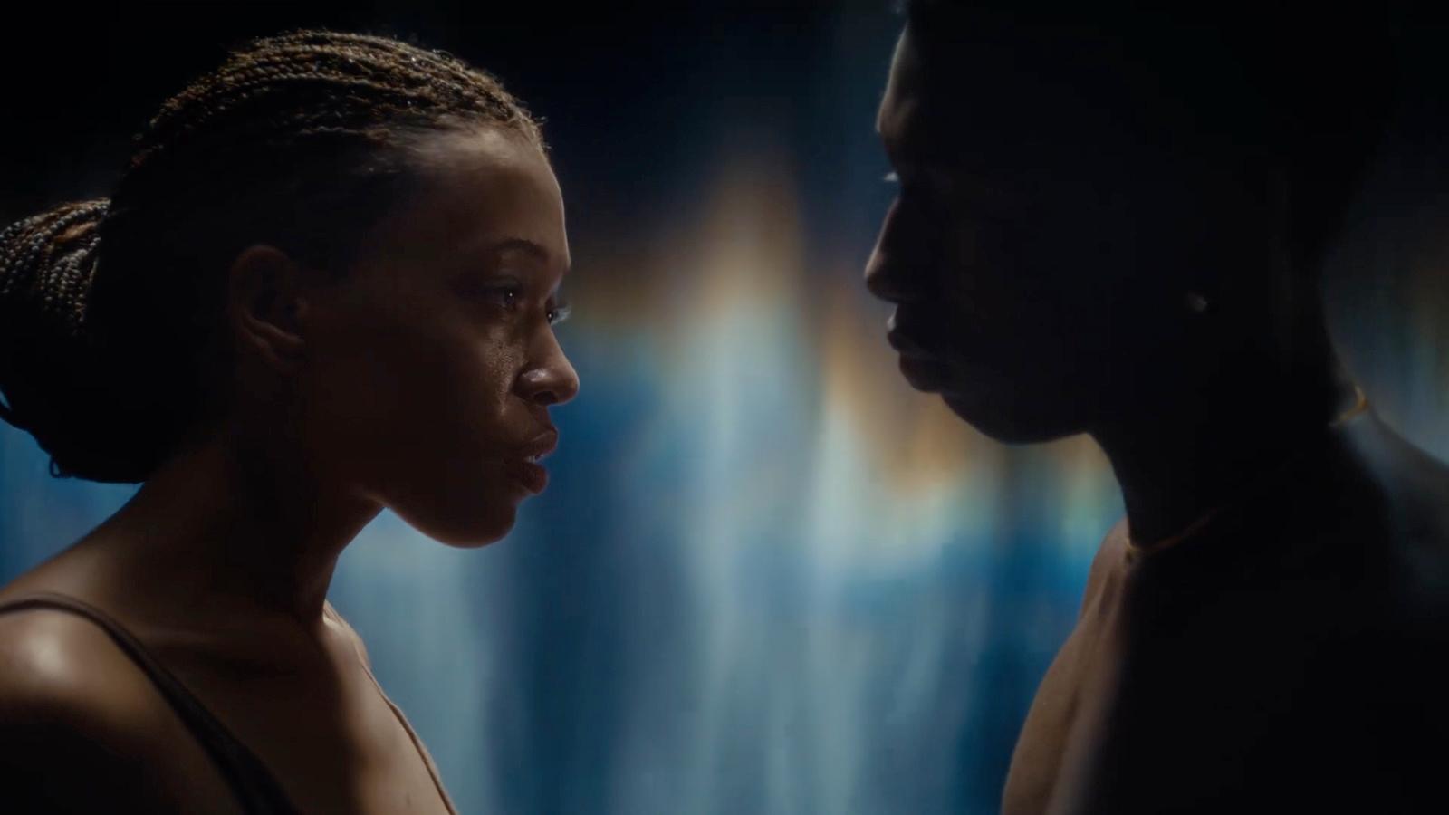 a woman standing next to a man in a dark room