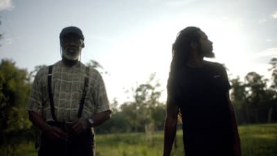 two men standing next to each other in a field