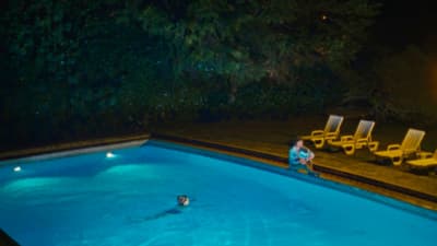 a person sitting in a swimming pool at night