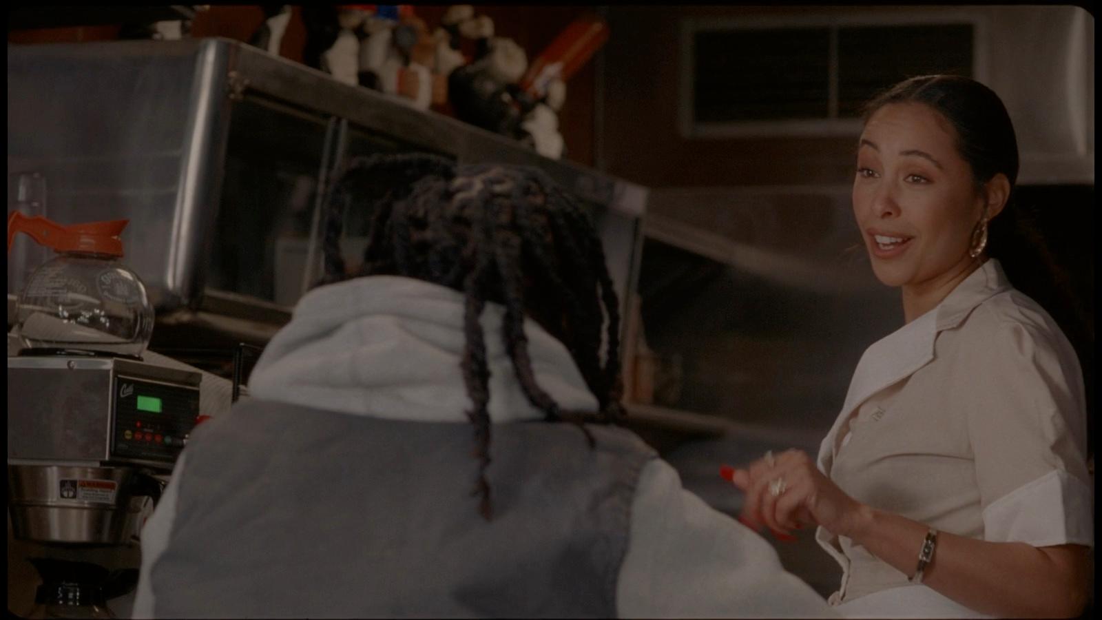 a woman with dreadlocks standing in front of a microwave