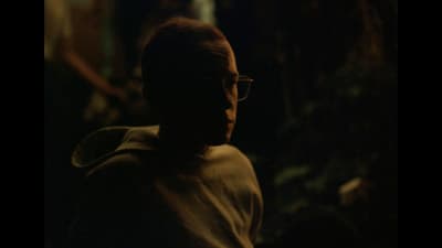 a man with glasses looking off into the distance