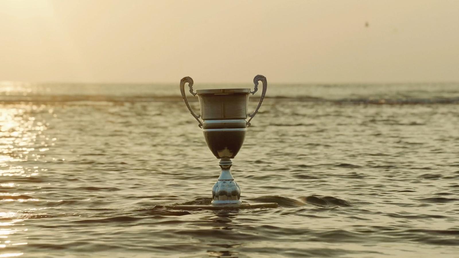 a trophy sitting in the middle of a body of water