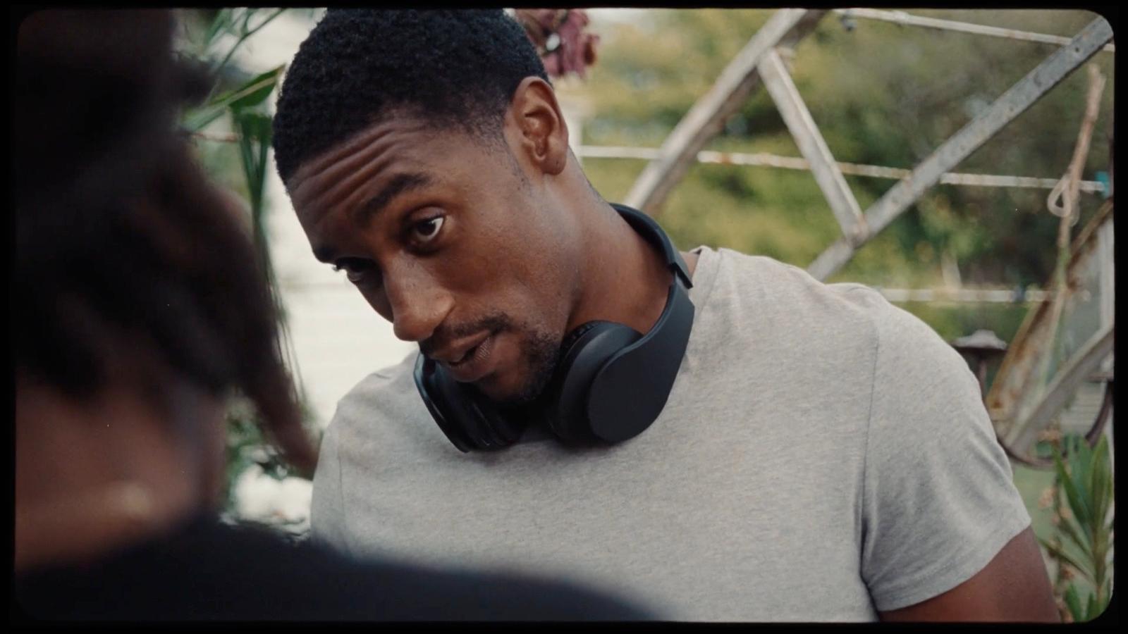 a man wearing headphones standing next to a woman