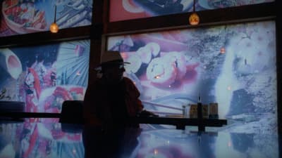 a man standing in front of a wall with pictures on it