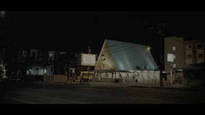 a building with a large triangular roof at night