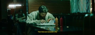 a man sitting at a table with a plate of food