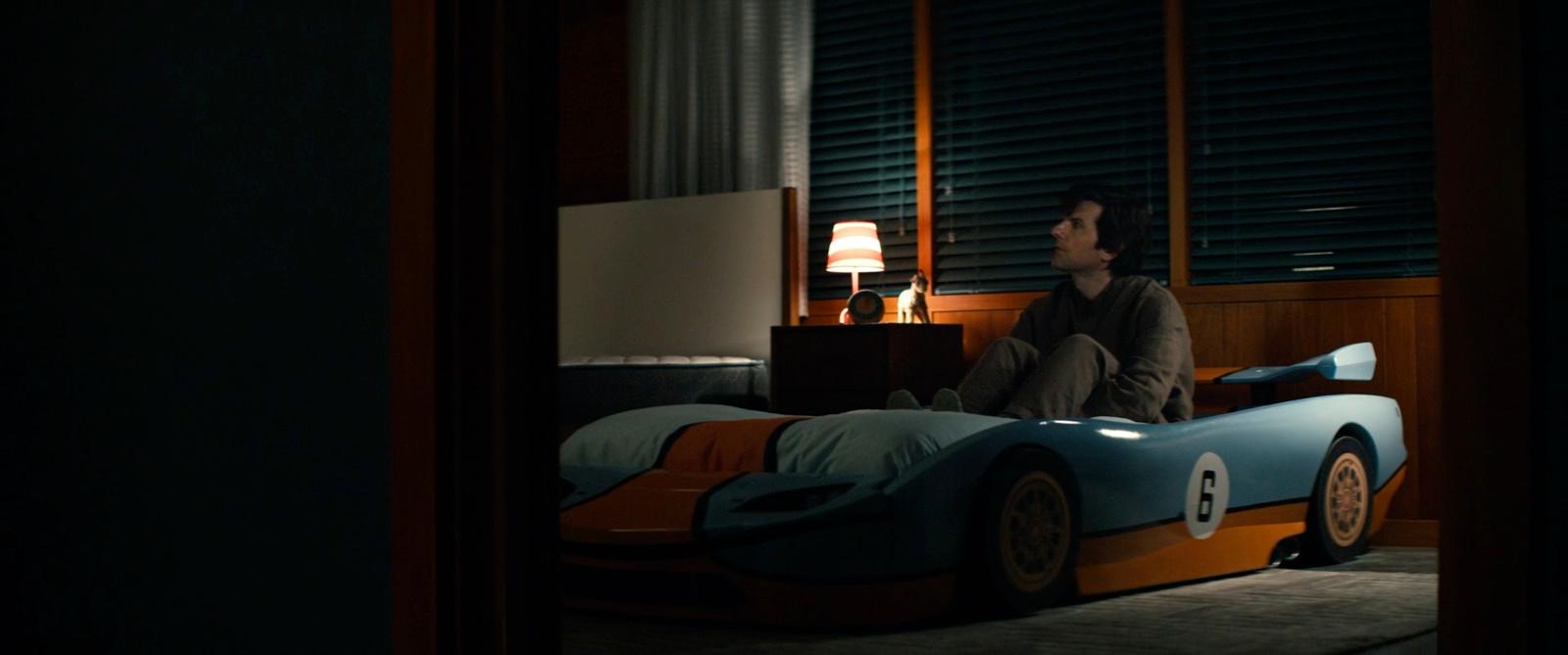 a man sitting on top of a bed in a bedroom
