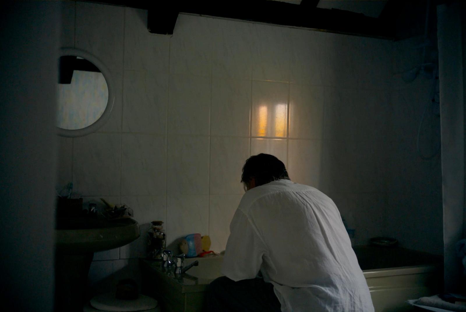 a man sitting on a toilet in a bathroom