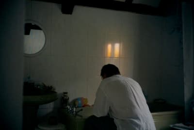 a man sitting on a toilet in a bathroom